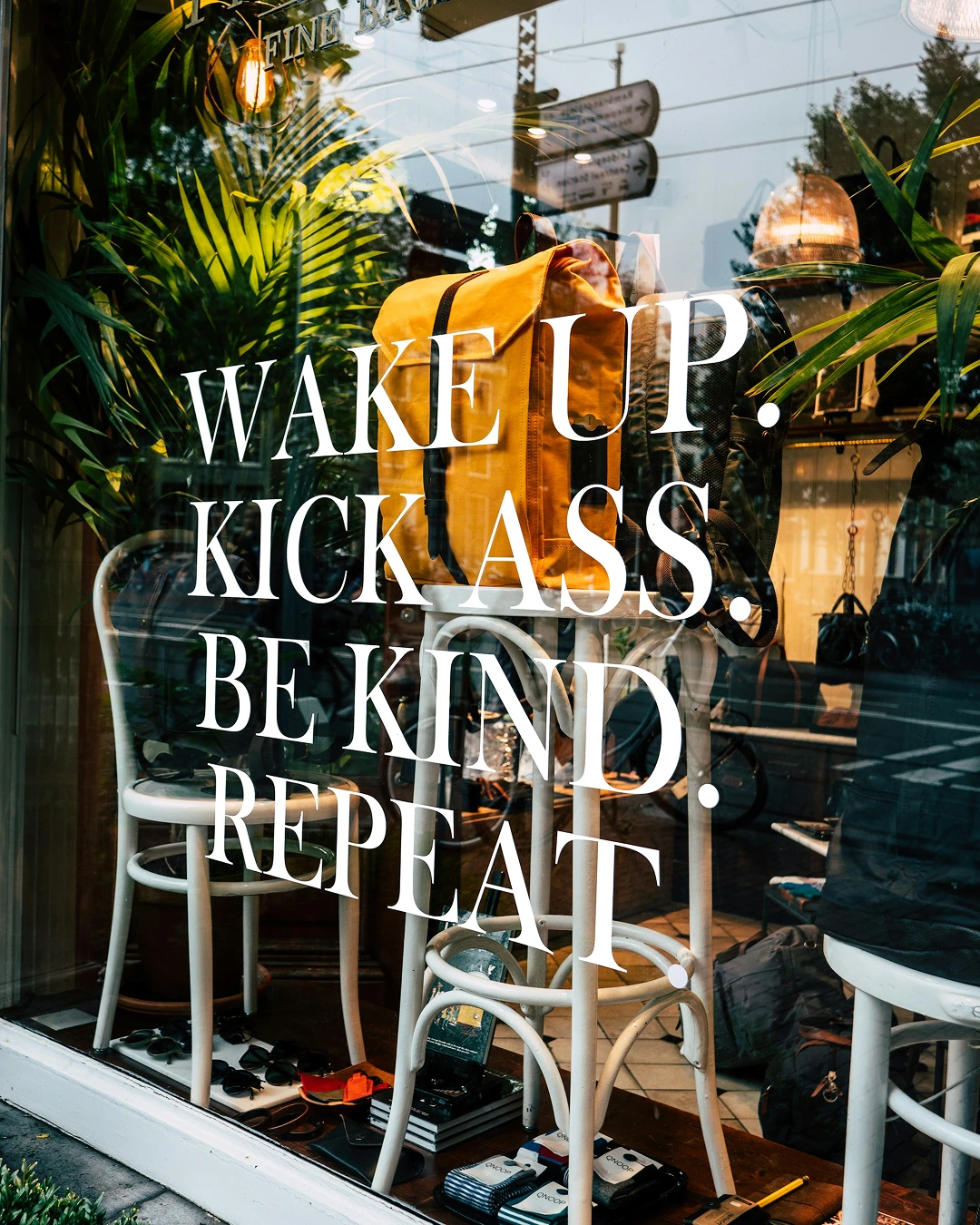 Quote zichtbaar op het raam met de tekst "Wake up, kick ass, be kind, repeat"
