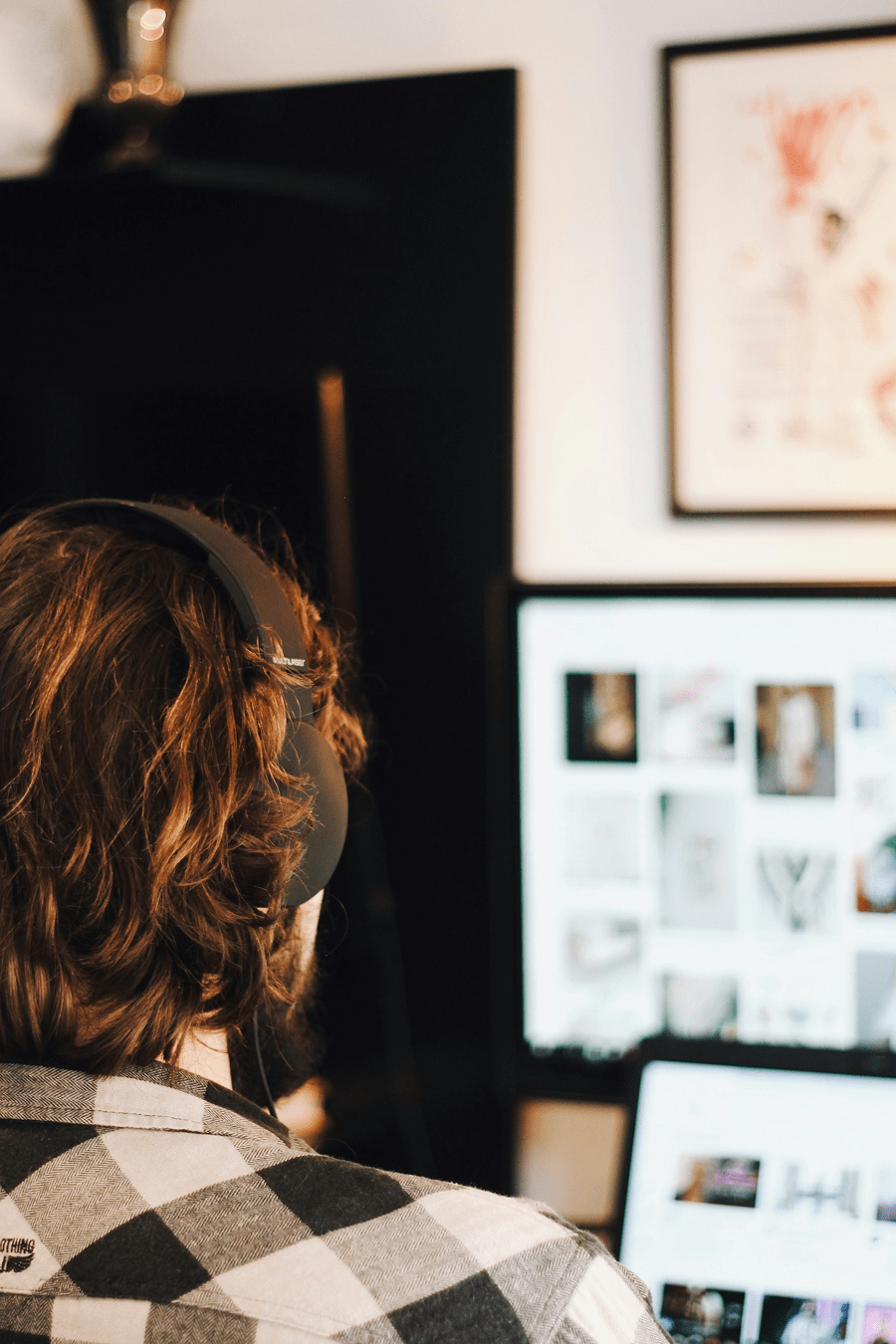 Persoon werkt aan een website met een headset op zijn hoofd.